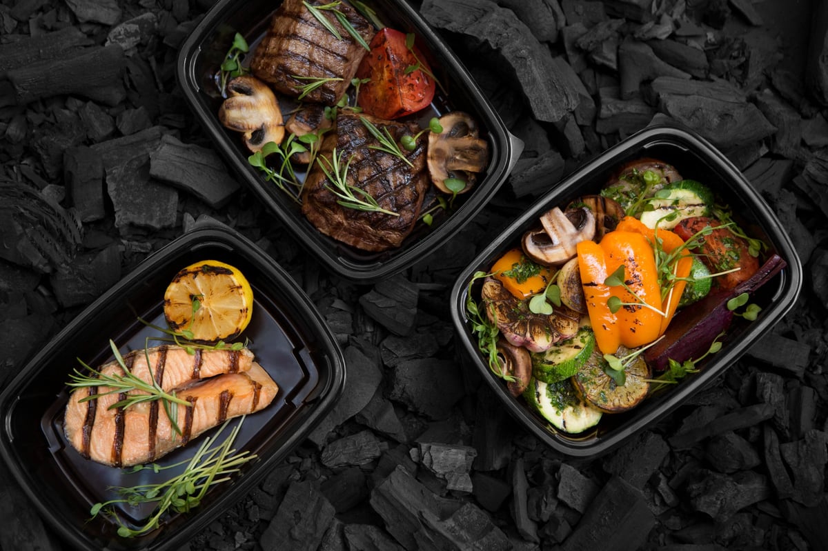 Fresh takeaway lunch boxes with grilled meat, fish and vegetables