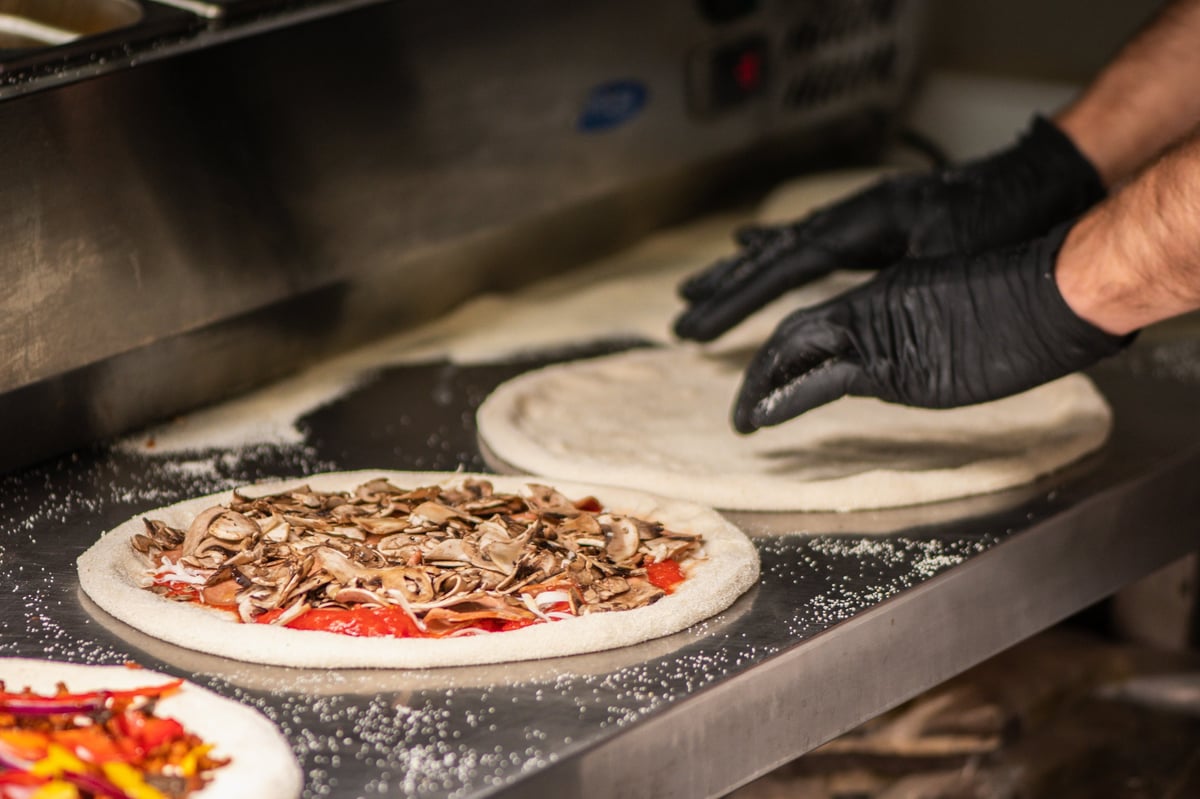Neapolitan-style pizza being prepared on a floured counter